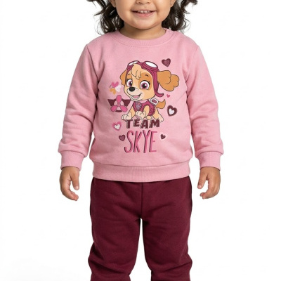 Criança com roupa rosa e bordeaux com estampa de cão e texto TEAM SKYE