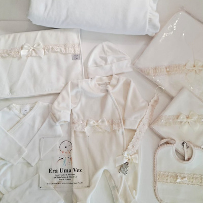 Conjunto de roupa de bebé branco com laços e renda creme e acessórios