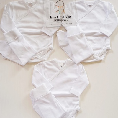 Conjuntos de roupas de bebé brancos com bodies de mangas compridas e calças, com cartão promocional ao centro.