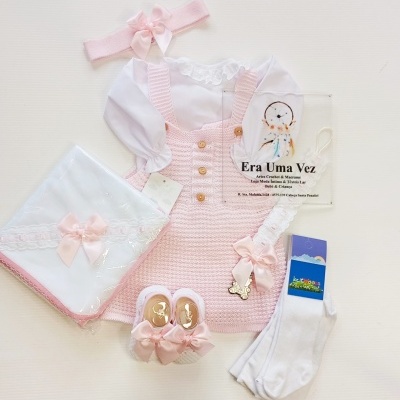 Conjunto de roupas e acessórios para bebé em tons de rosa e branco com placa Era Uma Vez