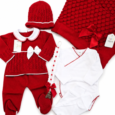 Conjunto de roupa para bebé vermelho e branco com gorro, macacão, body, manta, fita com laço e etiqueta.
