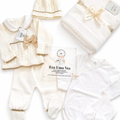 Conjunto de roupa de bebé creme e branco com acessórios e manta
