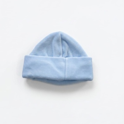 Gorro de bebé azul claro com dobra larga sobre superfície branca