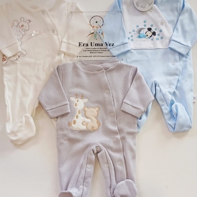 Três macacões de bebé em branco, azul claro e bege com bordados e botões