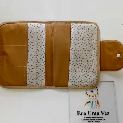 Organizador de tecido castanho e branco com padrão de estrelas castanhas.