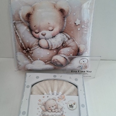 Produto para bebê com almofada e roupa de cama com desenho de ursinho
