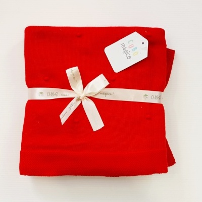 Manta vermelha de tricot com etiqueta e fita branca