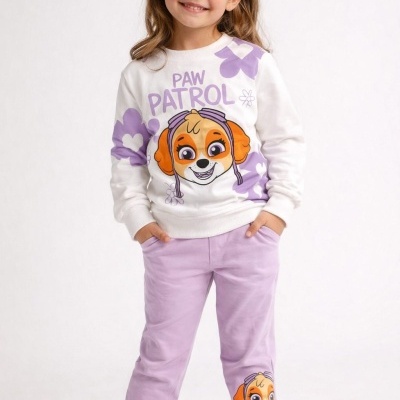 Criança vestindo conjunto Paw Patrol branco e lilás com personagens e flores.