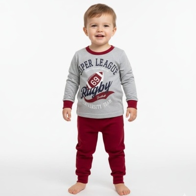 Criança com pijama cinzento e vermelho com texto sobre rugby