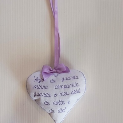 Coração branco em tecido com texto bordado e fita lilás para pendurar