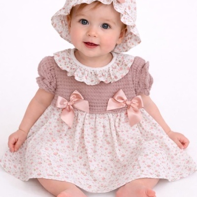 Bebé com vestido rosa antigo e floral e chapéu combinando