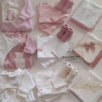 Conjunto de roupa de bebé em rosa e branco com bodies, casacos, meias e mantas bordadas