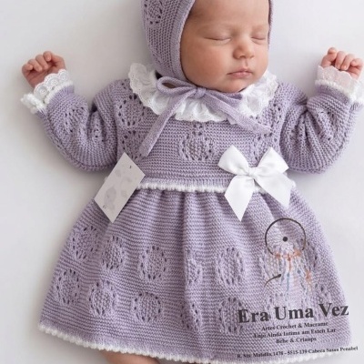 Bebé adormecido com vestido lilás de malha e gorro