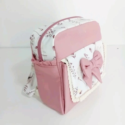 Mochila pequena rosa e branca com padrão floral e laço na frente