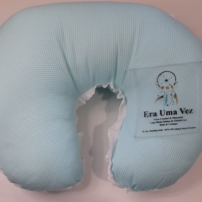 Almofada azul clara com renda branca e etiqueta transparente com texto e imagem de apanhador de sonhos