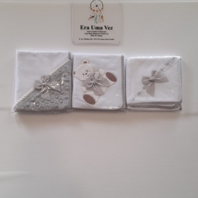 Três fraldas ou paninhos de bebé com laços cinzentos em fundo branco