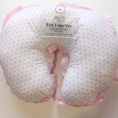Almofada de amamentação branca com estrelas cor-de-rosa e bordas cor-de-rosa.