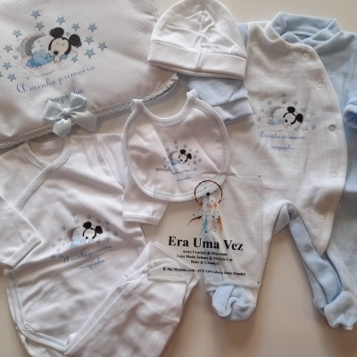 Conjunto de roupa de bebé branco e azul claro com personagem Mickey Mouse e texto 