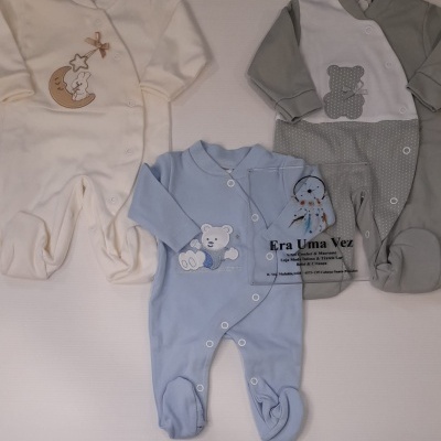 Três fatos de bebé com botões e bordados coloridos sobre fundo branco