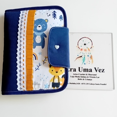 Capa de tecido azul escuro com padrão de animais e fecho com botão em forma de coração