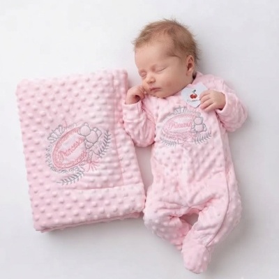 Bebé vestido com macacão rosa e manta rosa texturizada com bordados