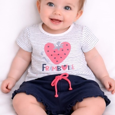 Bebé com camisola branca às riscas e calções azuis escuros