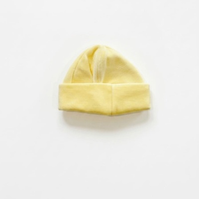 Gorro amarelo de bebé em tecido macio sobre fundo branco