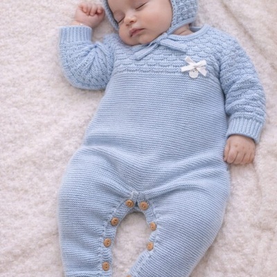 Bebé a dormir vestido com macacão azul claro de malha com capuz e botões de madeira