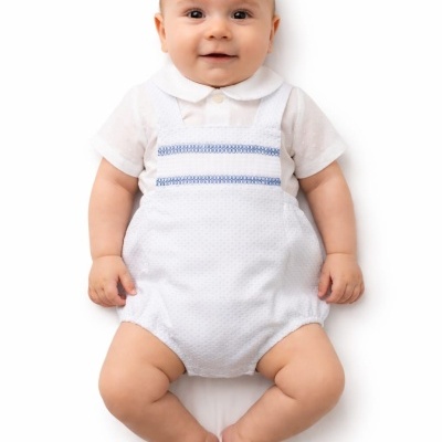 Bebé com macacão branco e linhas azuis no peito sobre fundo branco