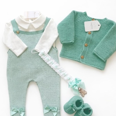 Conjunto de roupa de bebé verde água com acessórios em fundo branco