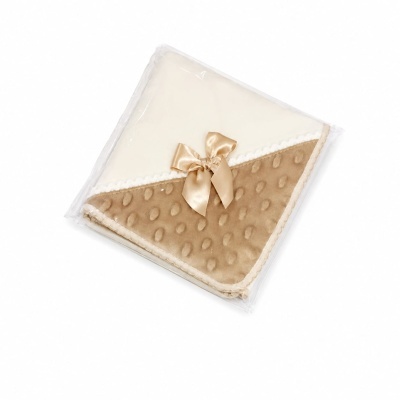 Manta creme e castanho com laço castanho embalada em plástico transparente.