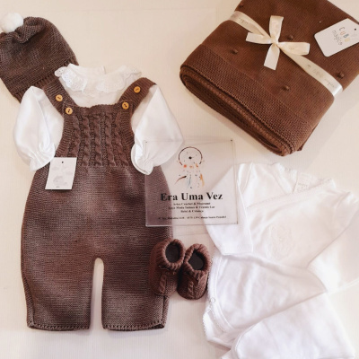Conjunto de roupa de bebé branco e castanho com body, macacão tricotado, sapatinhos e manta com etiqueta Cubo mágica