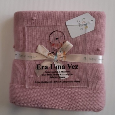 Manta cor-de-rosa em malha com laço branco e etiqueta com texto em fundo branco