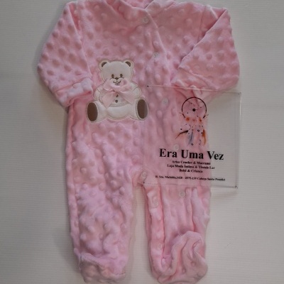 Macacão de bebé cor-de-rosa com textura de bolinhas, ursinho aplicado e laço.
