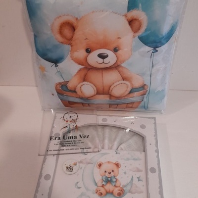 Roupa de cama infantil com ursinho e balões azuis em embalagem transparente