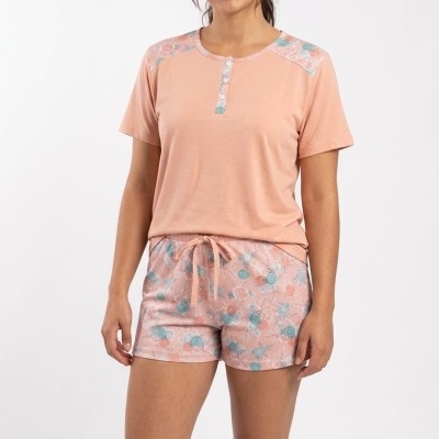 Pijama feminino rosa claro com detalhes florais e calções com padrão floral.