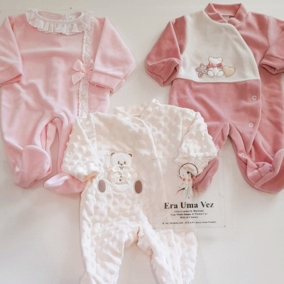 Macacões de bebé cor-de-rosa e branco com bordados e rendas sobre fundo branco com texto de loja.