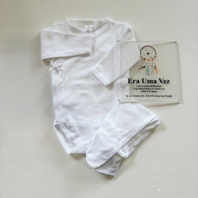 Body branco de manga comprida para bebé com botões de pressão e placa com texto sobre superfície branca