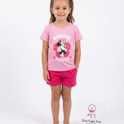 Menina criança com t-shirt rosa Minnie Mouse e calções rosa escuro em fundo branco