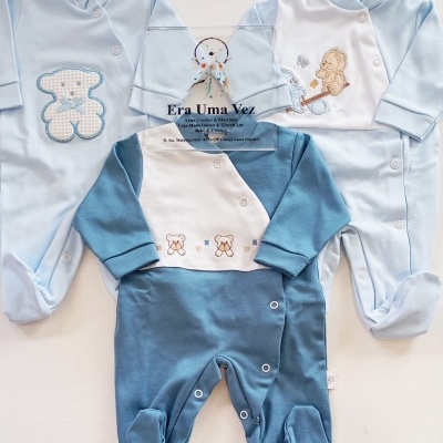 Três macacões de bebé em tons de azul com bordados de ursinhos e placa transparente com texto Era Uma Vez