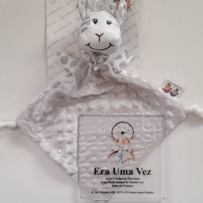 Brinquedo de peluche cinzento claro com cabeça de animal sorridente e textura de bolinhas