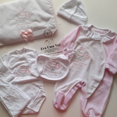 Conjunto de roupa de bebé branca e rosa com bordados cor-de-rosa e fralda bordada.