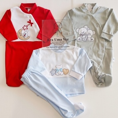 Conjunto de roupa de bebé em cores vermelho, azul e verde com estampados de animais e estrelas.