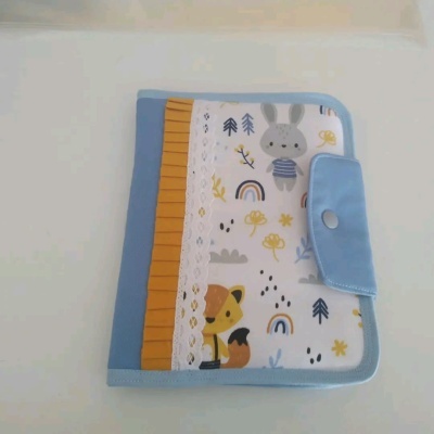 Estojo azul claro com estampados infantis e fecho de botão