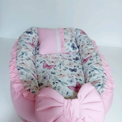 Ninho de bebé cor-de-rosa com estampado de borboletas e grande laço