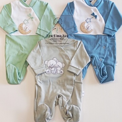 Três pijamas de bebé com botões e bordados coloridos, em tecido macio, sobre fundo branco