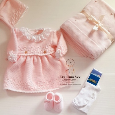 Conjunto de roupa de bebé rosa com vestido de tricô e gola com folho branco, sapatinhos, casaquinho e meias brancas