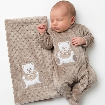 Bebé a dormir com pijama e manta castanhos decorados com urso bordado