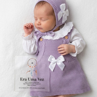Bebé a dormir vestido com vestido de malha lilás e gorro com laço branco