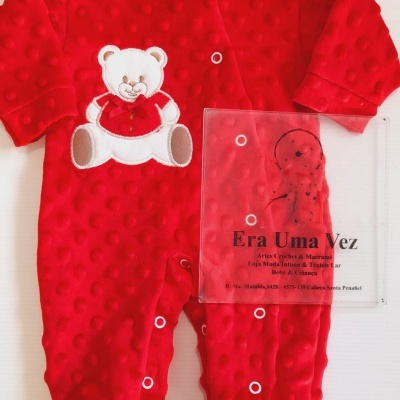 Macacão vermelho de bebé com ursinho aplicado e textura de bolas em relevo.
